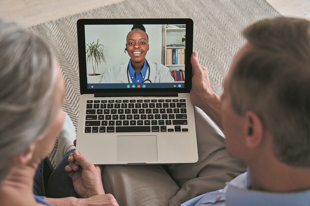 Over shoulder view of old grandparents couple patients video calling virtual doctor using laptop at home. Online telemedicine chat meeting. Seniors ehealth, telehealth consultation, tele medicine.