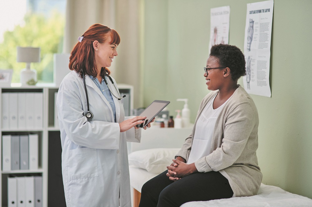 Shot of a doctor using a digital tablet during a consultation with a woman