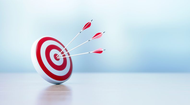 Success And Accuracy Concept - Red Dartboard and Arrows Sitting Before Defocused Background