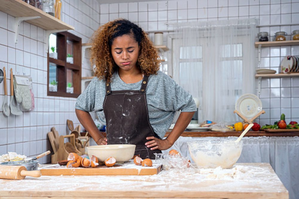 Young woman making a mistake during cooking.