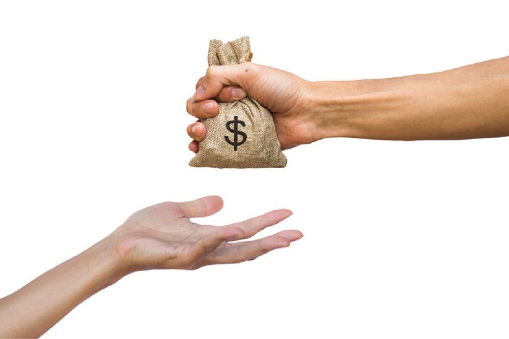 Cropped Hand Giving Money Bag Against White Background