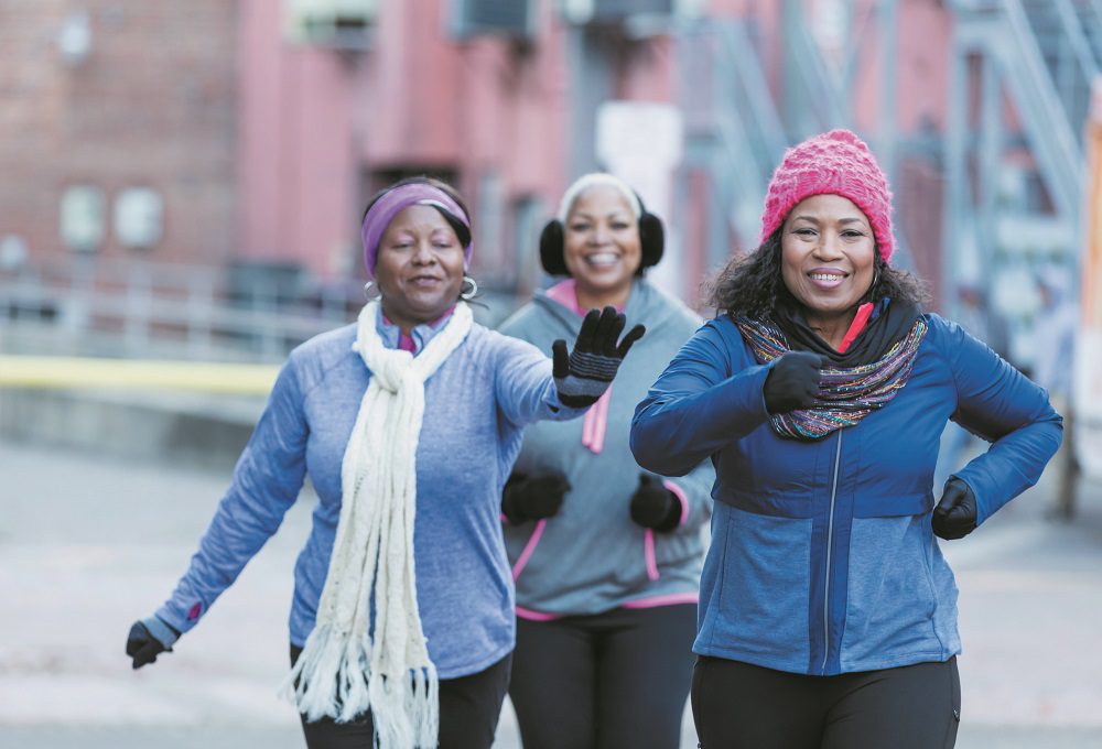 Senior African-American woman exercising with friends