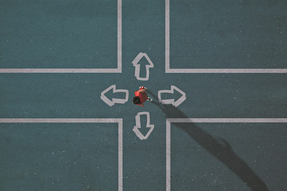 Girl dressed in red choosing direction at painted crossroad