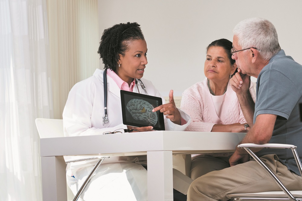 Doctor showing brain x-ray on digital tablet to patients