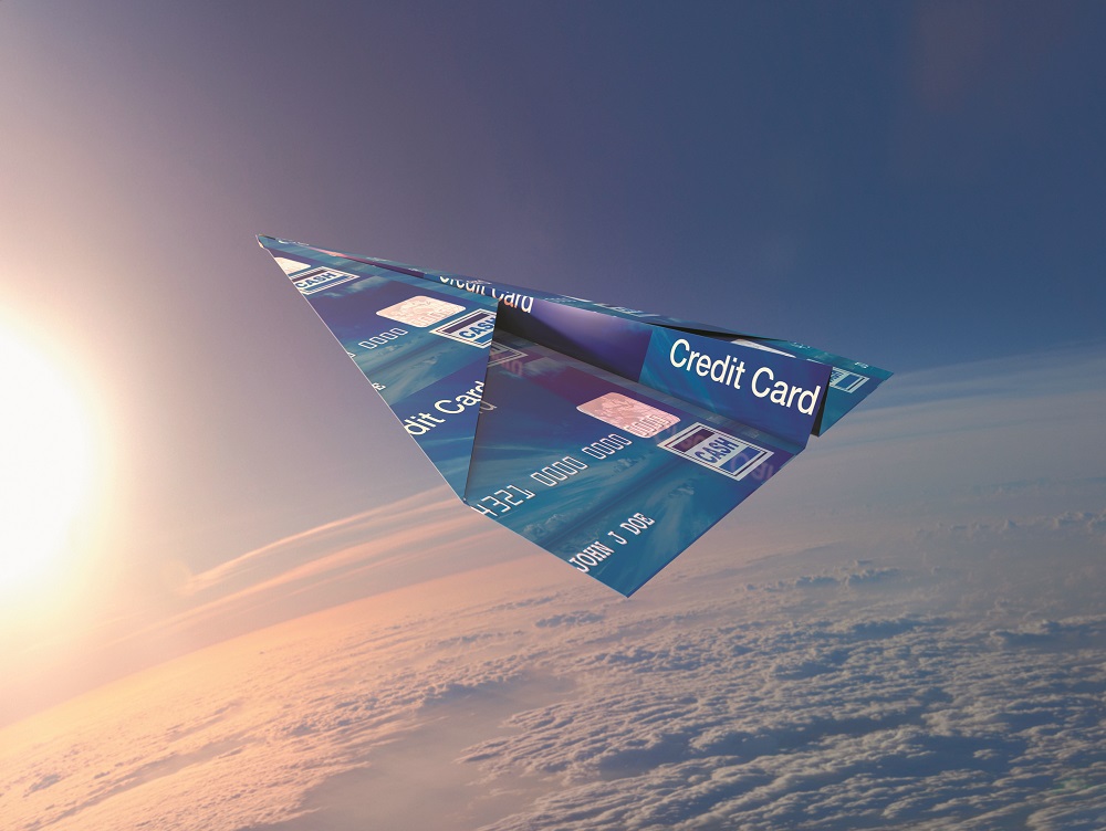 Credit card folded into paper airplane in atmosphere