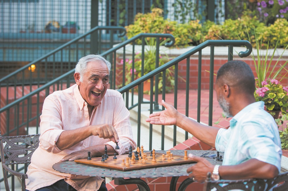Friends playing chess in garden
