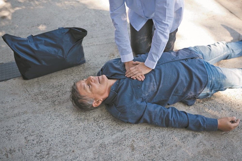 Woman giving first aid to a senior man