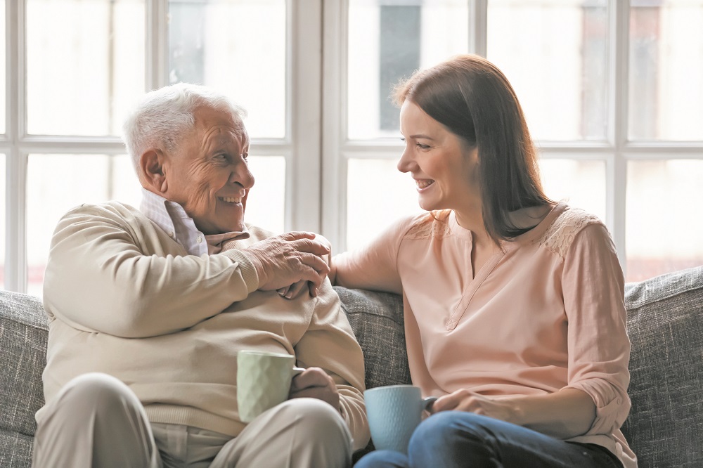 Elderly father enjoy conversation with daughter for cup of tea