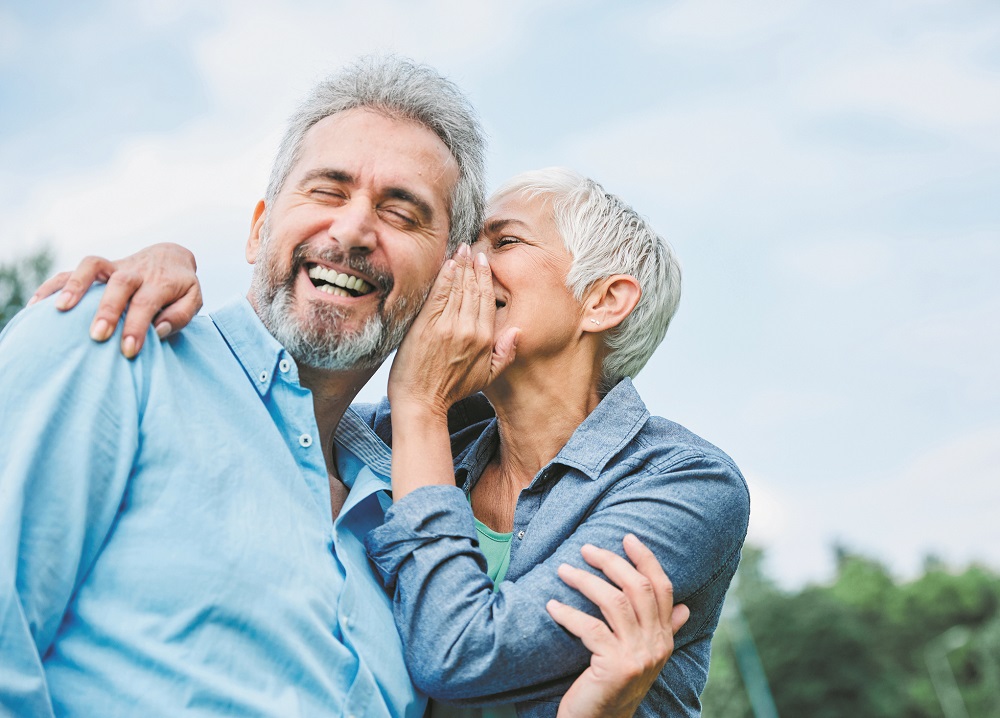 senior couple happy elderly love together retirement lifestyle smiling man woman mature ear gossip secret whispering whisper
