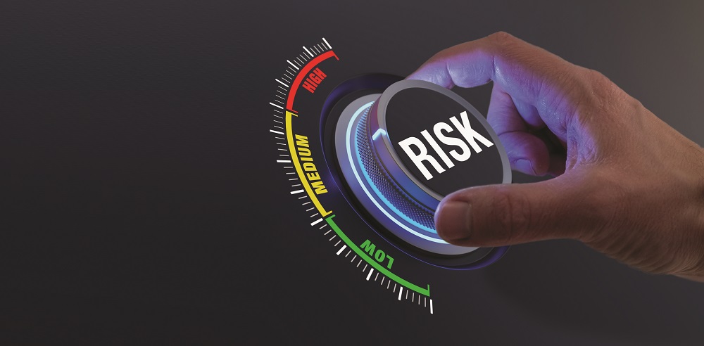 Risk management and mitigation to reduce exposure for financial investment, projects, engineering, businesses. Concept with manager's hand turning knob to low level. Reduction strategy.