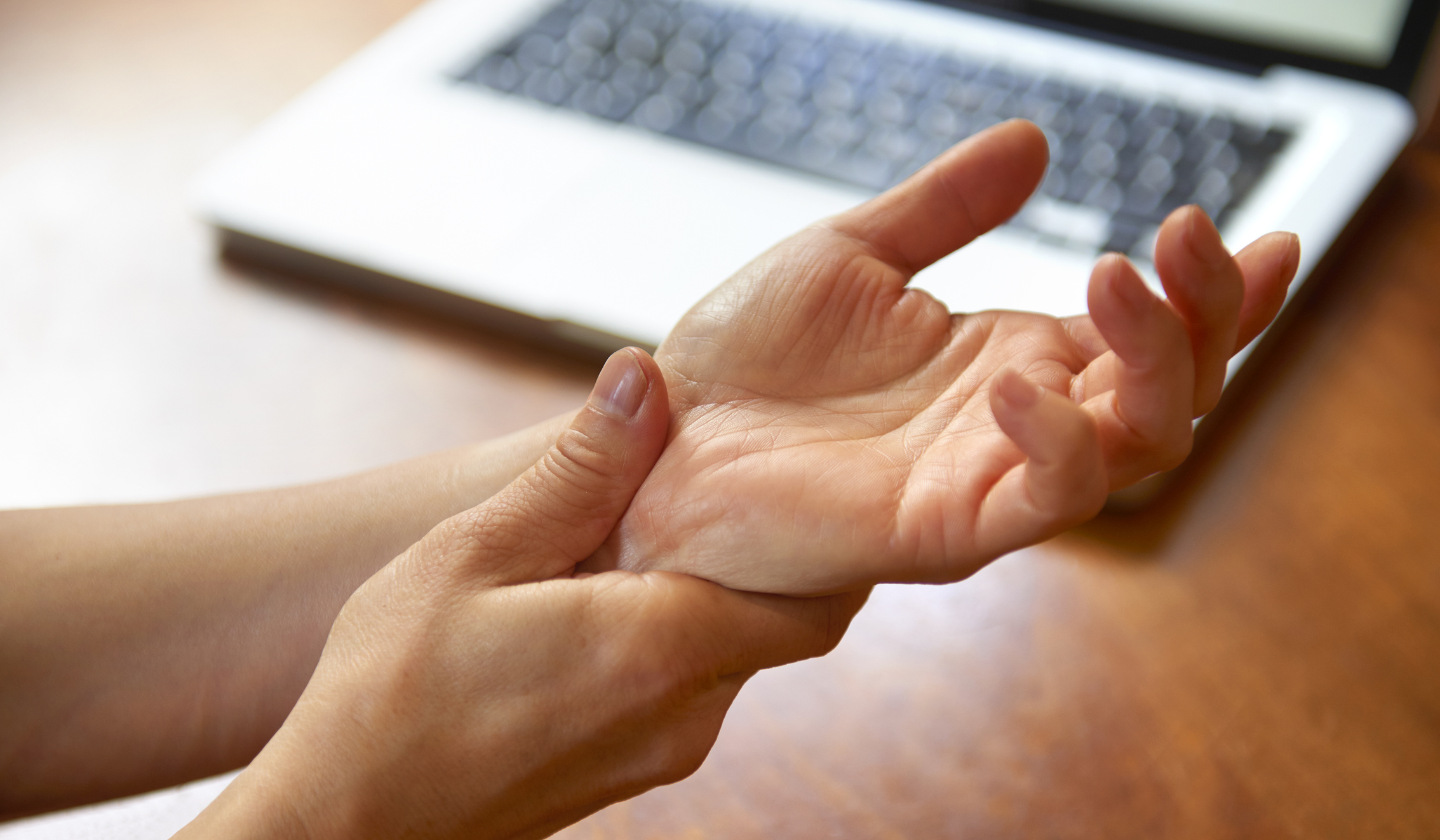 Woman massaging painful wrist at work repetitive strain injury
