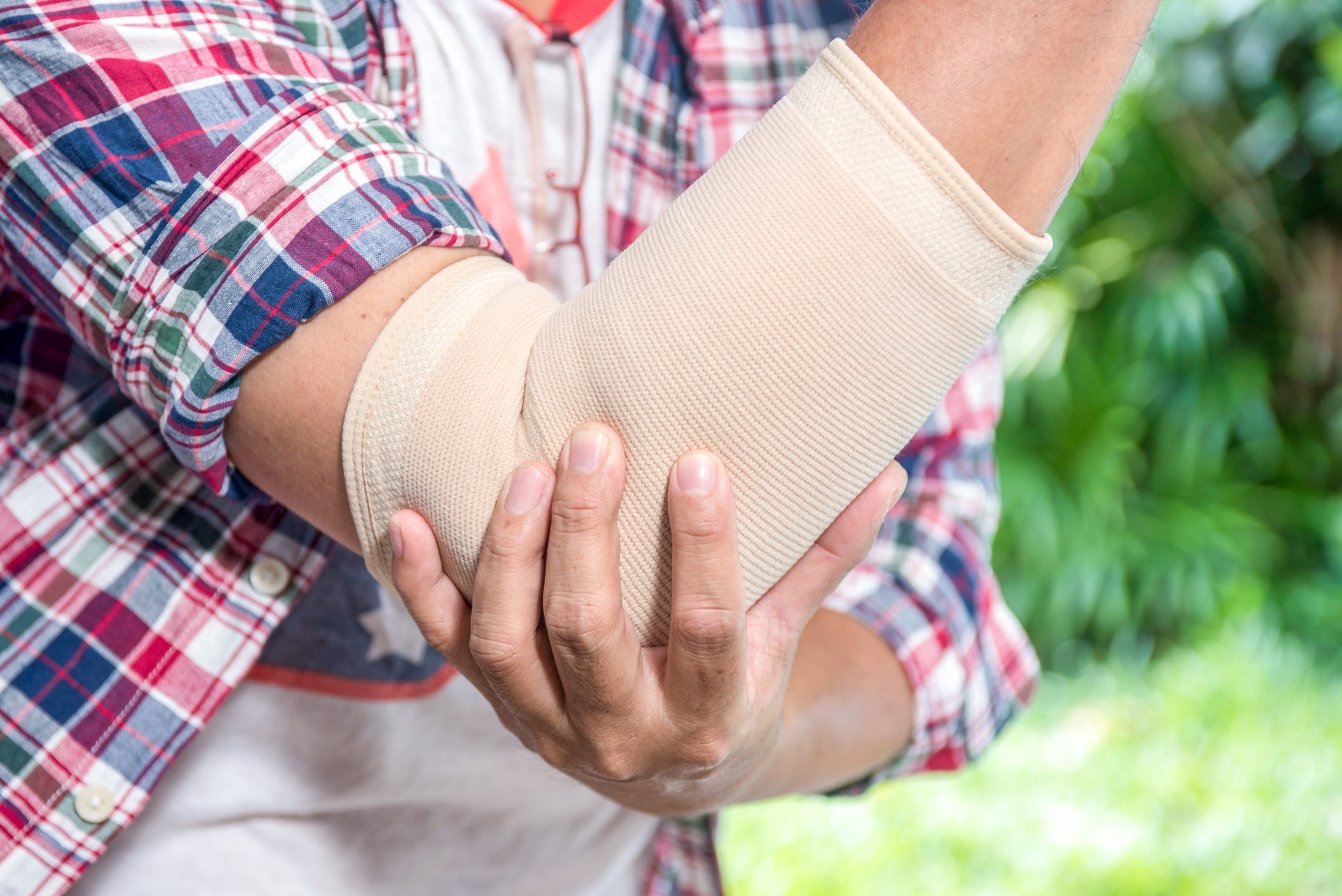 Man With Pain In Elbow. Pain relief concept