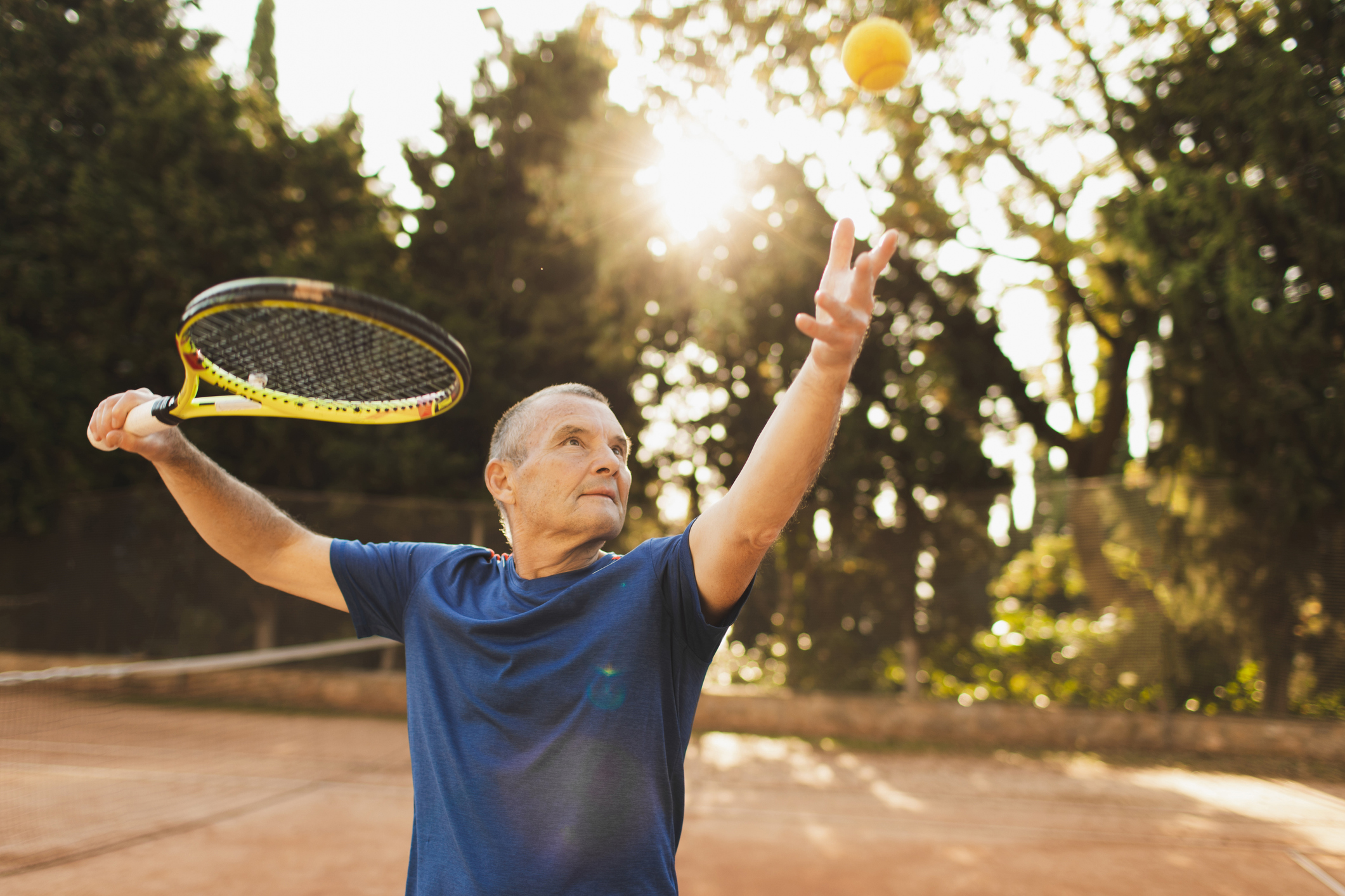 Serious and concentrated on game tennis player with racquet before pitch. Active senior man