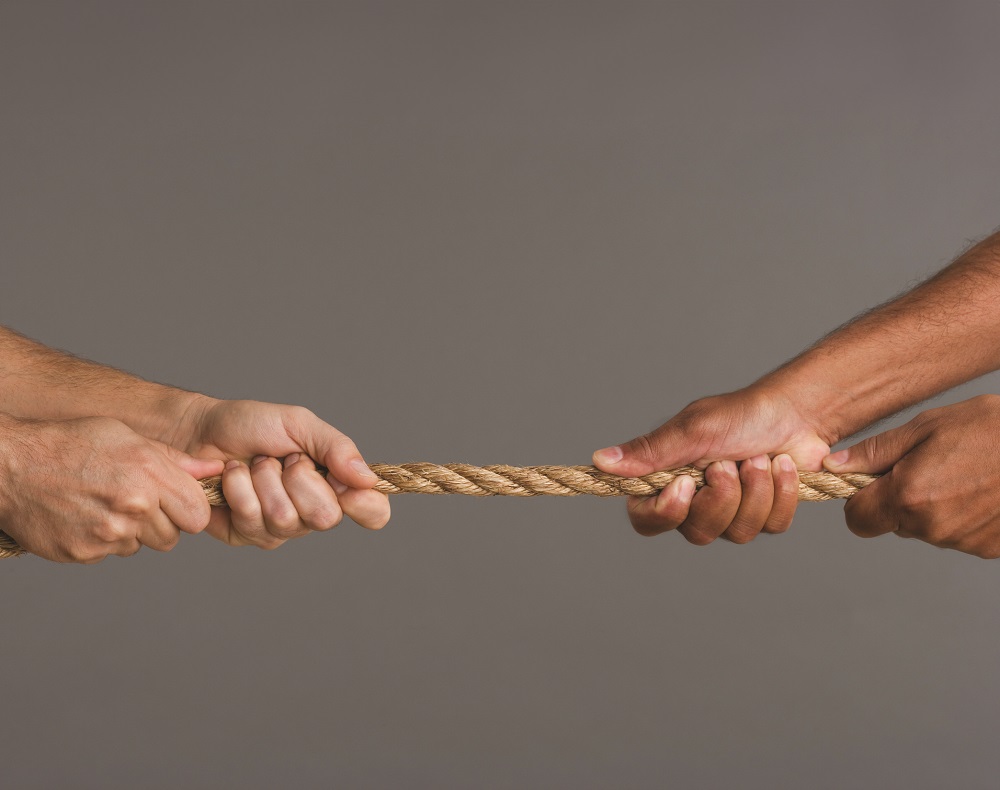 Close up of tug-o-war with four hands