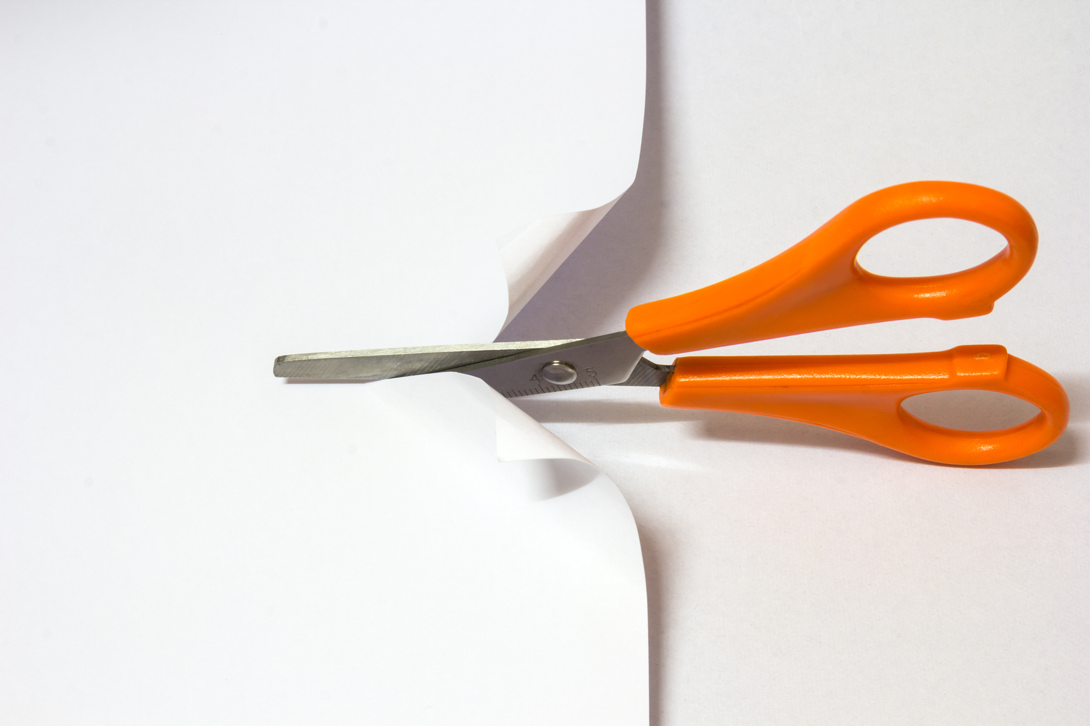 Scissor cutting white paper