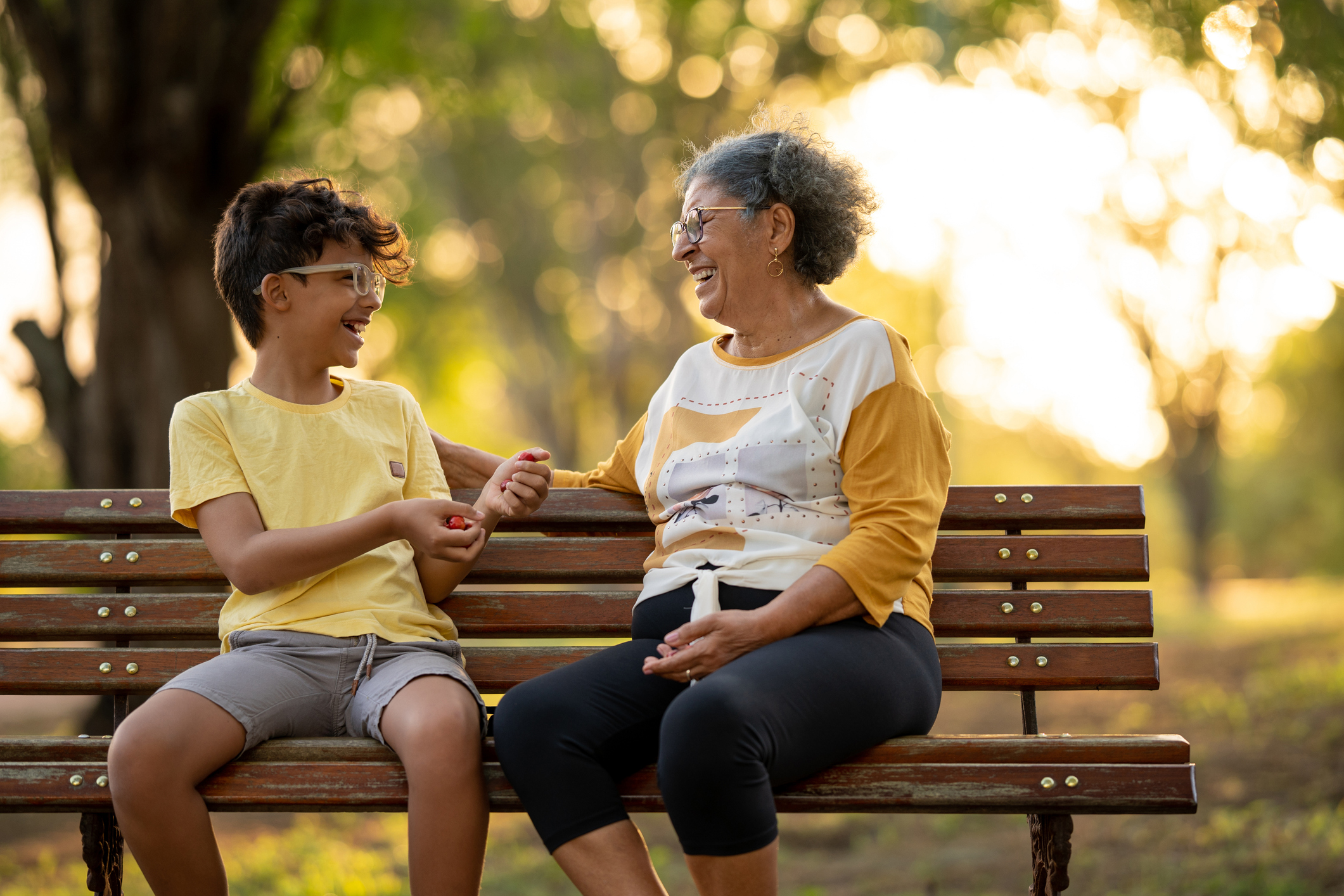 Grandmother and grandson sitting on the bench in the square