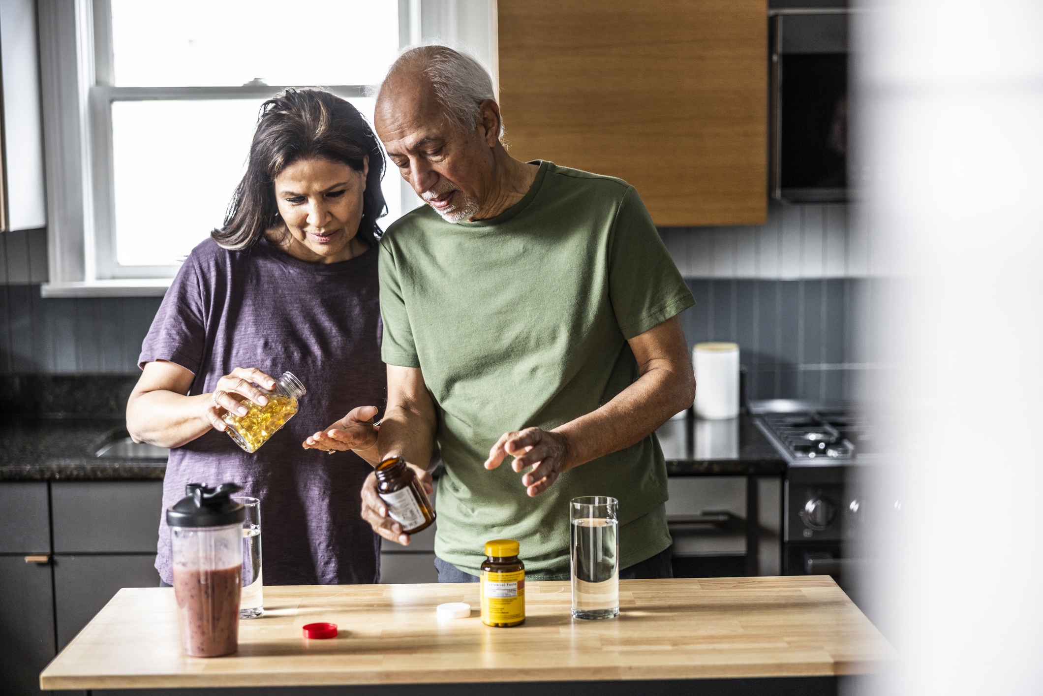Senior couple taking vitamins at home